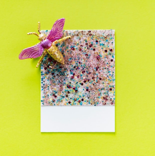 A collage featuring close-up shots of Y2K fashion accessories: glittery butterfly hair clips, colorful beaded necklaces, chunky plastic rings, and small, bedazzled shoulder bags. The accessories are arranged against a pastel pink background, creating a visually appealing and nostalgic display.