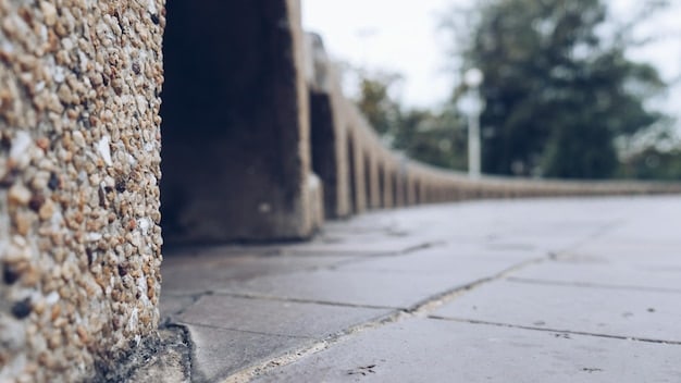 A close-up shot of a cobblestone street curving into the distance. The cobblestones create strong leading lines that draw the viewer's eye towards a blurred building in the background. The Instagram grid is superimposed, highlighting how the lines align with the grid to enhance the composition.