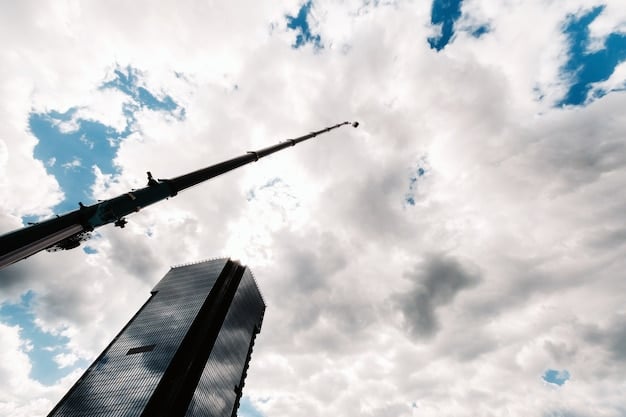 A low-angle shot of a tall skyscraper with the sky in the background. The strong vertical lines of the building are aligned with the grid, emphasizing the height and perspective. A few clouds add interest to the sky.