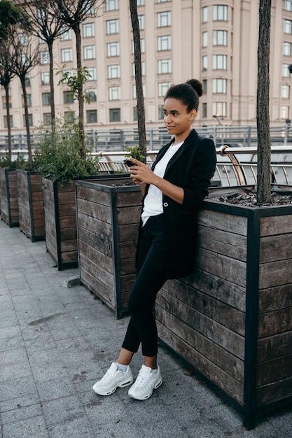 A Shein influencer wearing an oversized blazer paired with tailored trousers and stylish sneakers. The image showcases the blazer's versatility and how it can be dressed up or down for various occasions.