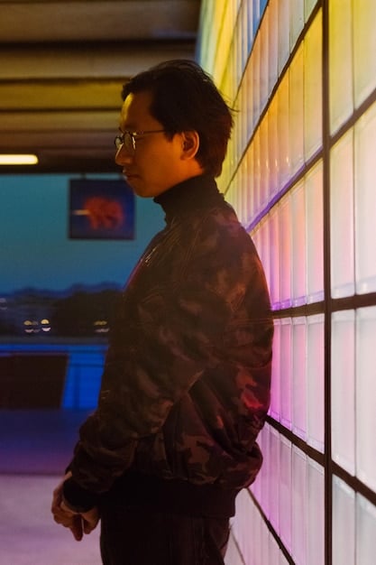 A person wearing a retro-futuristic outfit, possibly with holographic elements, standing in a dimly lit Tokyo-style street with neon signs. Focus on aesthetic details.