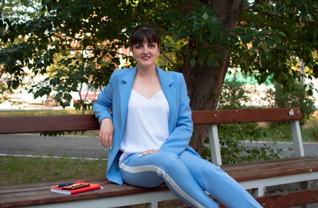 A young person, around 20, casually but stylishly dressed in loose-fitting, comfortable clothes, sitting on a brightly colored beanbag and laughing while looking at their phone. Their outfit combines elements of comfort with a touch of personal flair, representing authentic, real-life styling.