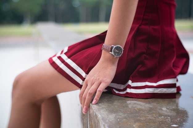 A close-up shot of a person's hand subtly adjusting an intricate bracelet, with a stylish watch just visible on the wrist and a textured fabric of their sleeve in the background, all in soft focus.