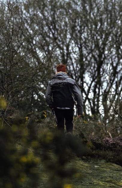 A person walking away from the camera in a scenic outdoor setting, capturing a feeling of natural movement and adventure.