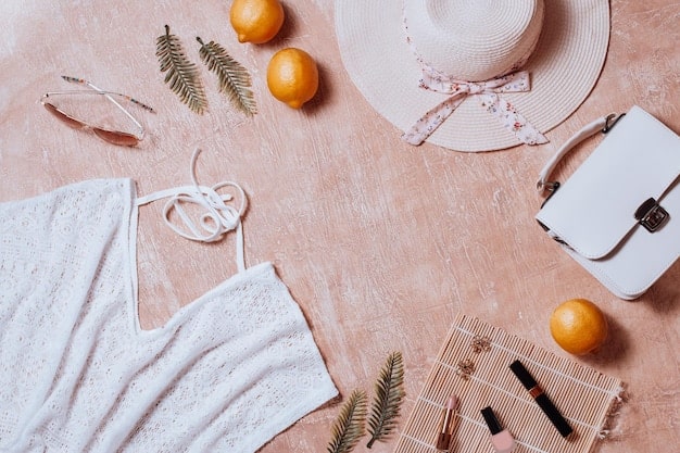 A beautifully arranged flat lay displays a curated selection of pre-owned, vintage, and ethically produced clothing items and accessories, symbolizing thoughtful consumption versus fast fashion.