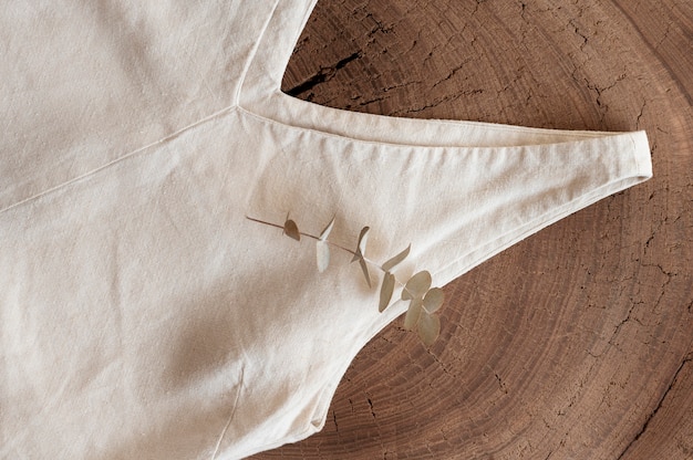 A minimalist flat lay shows a natural cotton tote bag with a 