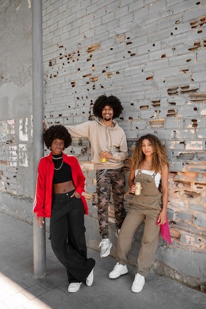 A street style photograph featuring a diverse group of individuals embracing utilitarian fashion, with cargo pants, oversized utility jackets, and functional accessories. The setting is an urban environment with brick walls and soft, natural light, highlighting the textures of their durable fabrics.