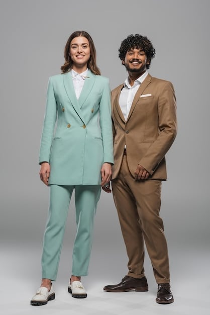 Two young professionals, one in a smart-casual blazer and the other in a stylish dress, are engaged in a dynamic conversation in a modern office. The image reflects a contemporary workplace and the importance of dressing appropriately for the company culture, aligning with How to Dress for a Job Interview: A 2025 Style Guide for Making a Lasting Impression.