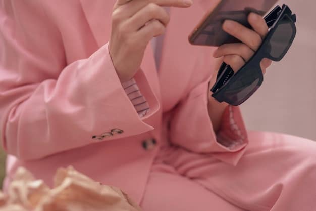 A close-up shot of a fashion influencer's hands meticulously arranging clothing and accessories for a flat lay photo. The setting conveys meticulous curation of fashion content and attention to detail.