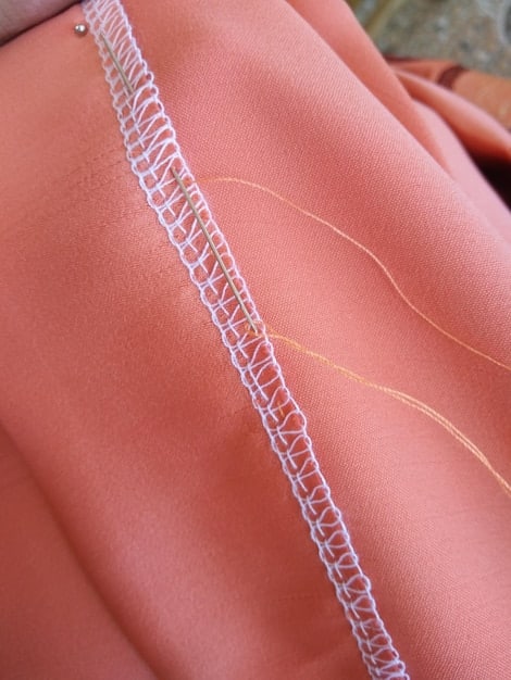 A detailed close-up of the stitching and seams on a plus-size garment from Shein, highlighting the quality of the construction. Threads are neatly aligned, and the fabric appears durable. The background is blurred to keep the focus on the craftsmanship of the clothing item. The image represents a focus on the build quality of a Shein Plus-Size Clothing Haul: Honest Review and Fit Guide for 2025, specifically the stitching details.