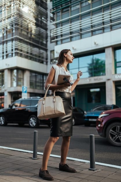 A person confidently walking down a city street, carrying a luxury handbag. The bag is stylishly coordinated with their outfit, exuding sophistication and personal style. The backdrop is a bustling urban environment, suggesting the bag as an accessory to an active and fashionable lifestyle. The overall impression is one of confidence, success, and the ability to express individuality through fashion. The image showcases the emotional value of Unboxing a Luxury Handbag Haul: Is It Worth the Splurge in 2025?.