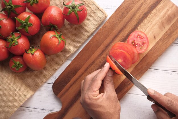 Close-up shot of a hand using a small kitchen gadget to effortlessly slice a tomato. The gadget is simple and the results are uniform slices. The focus is on illustrating the problem-solving aspect of viral gadgets as part of 